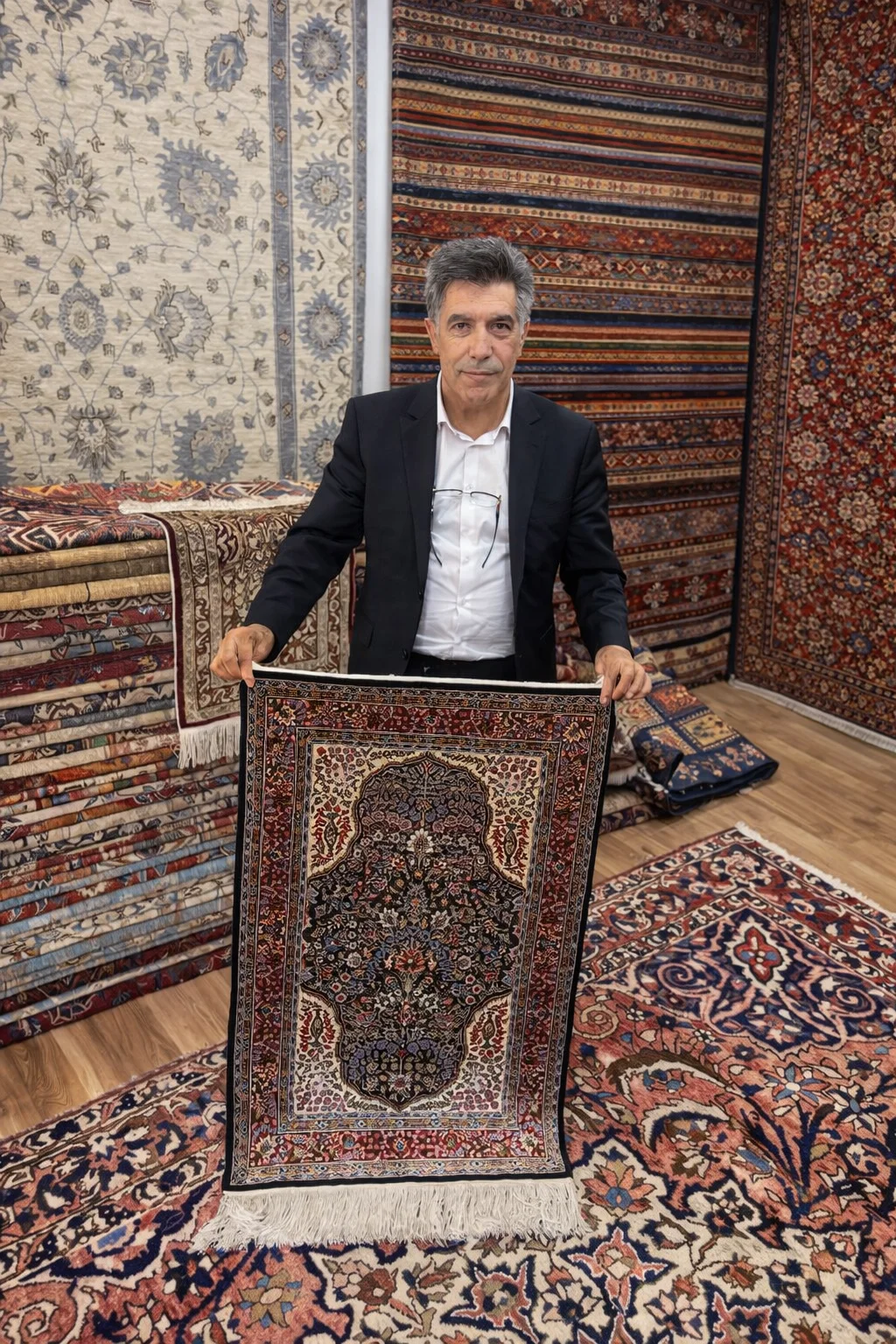 Edip Günes präsentiert einen Ghom Seidenteppich bei persönlicher Beratung, ED.GUENES Teppiche